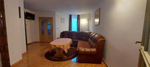 a living room with a leather couch and a table at La cabana bunicului in Sibiu