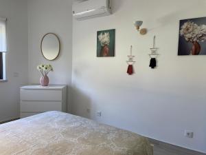 ein weißes Schlafzimmer mit einem Bett und einem Spiegel in der Unterkunft Quinta Nova 103 in Alvor