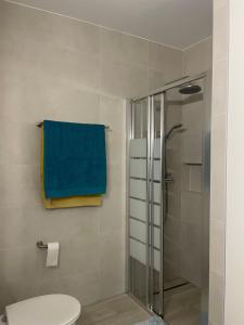 baño con ducha y toalla azul en Quinta Nova 103, en Alvor 14 fotos más