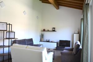 een woonkamer met een bank, 2 stoelen en een tv bij Apartamento El Mirador de la Rua in Estella