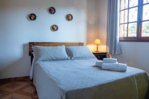 a bedroom with a bed with two towels on it at pousada helebastian in Campos do Jordão
