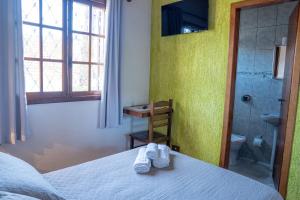 a bedroom with a bed and a bathroom with a shower at pousada helebastian in Campos do Jordão