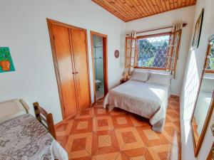 a small bedroom with a bed and a window at pousada helebastian in Campos do Jordão