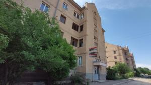 un grand bâtiment avec un arbre devant lui dans l'établissement Apartment 11, à Gyumri