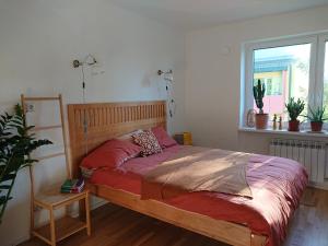 a bedroom with a bed with red sheets and a window at Õdus korter roheluses - A cozy apartment in a greenery - contactless check-in in Põlva