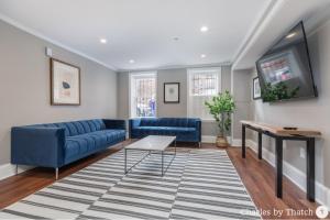 a living room with a blue couch and a table at 94 Charles Street by Thatch in Boston