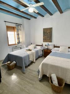 1 dormitorio con 2 camas y ventilador de techo en El mirador de María, en Alcalá del Júcar