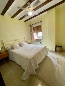 1 dormitorio con 1 cama grande con colcha blanca en El mirador de María, en Alcalá del Júcar