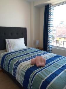 a bedroom with a large bed with a window at Buena Vista Apartment in Cusco