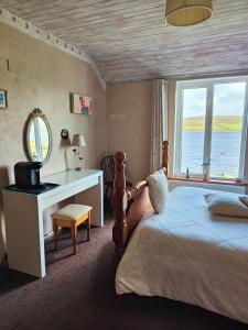 a bedroom with a bed and a desk and a window at Waterfront Rest B&B in Clifden