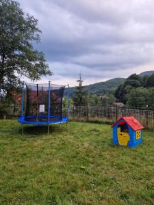a playground with a trampoline and a dog house at Poarta Zaganului Cheia in Cheia