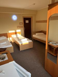 a hotel room with two beds and a mirror at Hotel Monte Carlo in Piteşti +21 photos