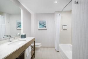a white bathroom with a sink and a toilet at Hyatt Place Panama City Beach - Beachfront in Panama City Beach