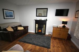 a living room with a couch and a fireplace at Mullarts Church Apartments - The Glencorp Apartment in Knocknacarry +13 photos