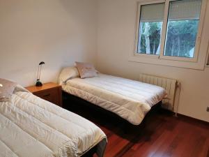 1 dormitorio con 2 camas y ventana en Villa Playa y Montaña, en Cunit