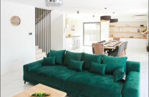 a living room with a green couch and a table at Villa BO in Koprivno