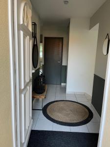 - un couloir avec un tapis rond sur du carrelage dans l'établissement Villa du Golf Eden Parc, à Lacanau-Océan