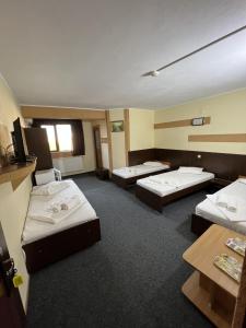 a hotel room with three beds and a tv at Hotel Monte Carlo in Piteşti