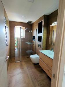 a bathroom with a toilet and a sink and a shower at Maravillosa casa con piscina grande y bosque in Tordera