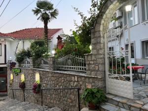 a house with a stone wall and a fence at Villa Metulevi in Ohrid