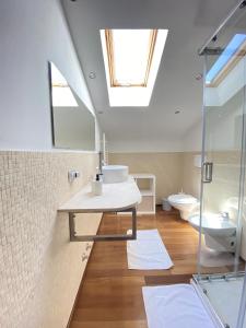 łazienka z umywalką, toaletą i oknem dachowym w obiekcie Casa Alda w mieście La Spezia