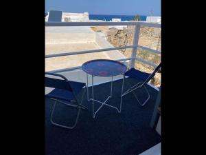 stół i dwa krzesła na balkonie w obiekcie Studio Seagull - By Old Market Street - Naxos Town w mieście Naksos