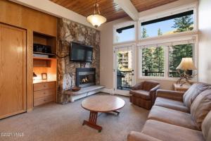 a living room with a couch and a fireplace at Slopeside 2 Bedroom Gold-rated Residence At Golden Peak In Vail Village in Vail