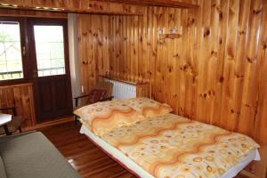 a bedroom with a large bed in a room with wooden walls at Eko-Sen in Białowieża