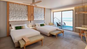 two beds in a room with a view of the ocean at Haven Riviera Cancun - All Inclusive - Adults Only in Cancún