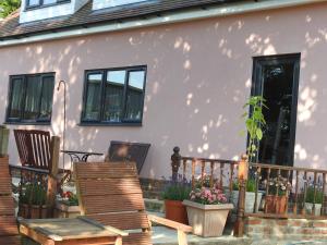 a house with two chairs and a fence at The Shed @ Stares Farm Cottage in Shedfield