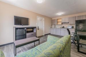 a living room with a couch and a flat screen tv at Super 8 by Wyndham Lake Charles Northeast in Lake Charles