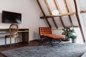 a living room with a television and two chairs at Châteauhotel De Havixhorst in Schiphorst