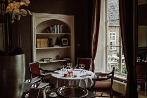 uma sala de jantar com uma mesa com copos de vinho em Châteauhotel De Havixhorst em Schiphorst