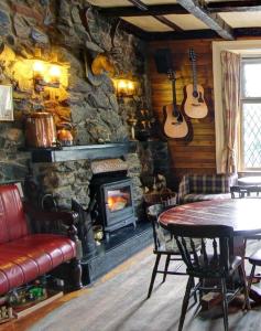 ein Steinzimmer mit einem Tisch und einem Kamin in der Unterkunft Bonnie Banks Lodge Ardlui in Ardlui