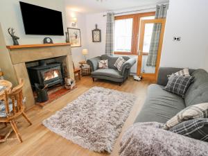 a living room with a couch and a fireplace at 19 The Village in Holmfirth