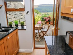 a kitchen with a view of a patio with a table at 19 The Village in Holmfirth