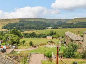 a view of a farm with a building and a field at 19 The Village in Holmfirth