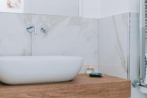 bagno con lavandino bianco e bancone in legno di FronteMare Suite a Castellammare di Stabia Altre 20 foto