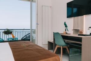 una cucina con scrivania e tavolo con sedia verde di FronteMare Suite a Castellammare di Stabia