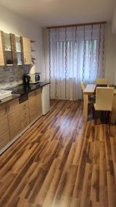 a kitchen with a wooden floor and a dining room at ANI Apartments Banja Luka in Banja Luka
