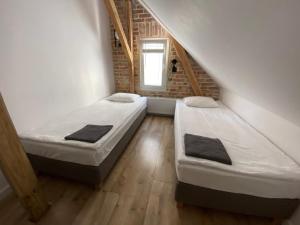 Duas camas num pequeno quarto com uma parede de tijolos em Hostel 19 Sopot em Sopot