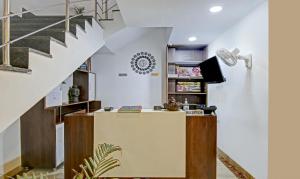 una escalera que conduce a una sala de estar con escritorio en Treebo Trend Royal Empire Adarsh Nagar Chandigarh, en Chandīgarh