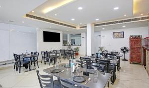 a restaurant with tables and chairs and a flat screen tv at Treebo Trend Royal Empire in Chandīgarh