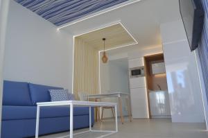 een woonkamer met een blauwe bank en een tafel bij Alsol Bungalows Todoque - Adults Only in Playa del Inglés