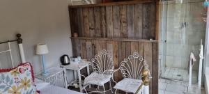 a living room with two chairs and a shower at Die Pastorie in Caledon