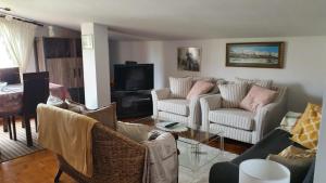 a living room with two couches and a tv at LOFT SUSANA in San Vicente de la Barquera