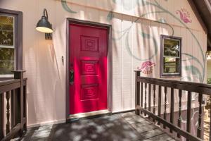 a red door on the side of a house at Folly Vacation Vintage Cottage with Stunning Views 218 in Folly Beach