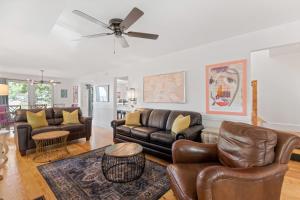 a living room with leather furniture and a ceiling fan at Folly Vacation Vintage Cottage with Stunning Views 218 in Folly Beach