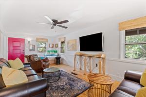 a living room with a couch and a flat screen tv at Folly Vacation Vintage Cottage with Stunning Views 218 in Folly Beach