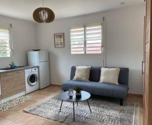 a living room with a blue couch and a table at Appartement cosy & calme en Rez de villa in Saint-François